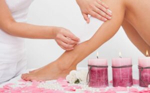 Beautician Waxing A Woman's Leg Applying Wax Strip